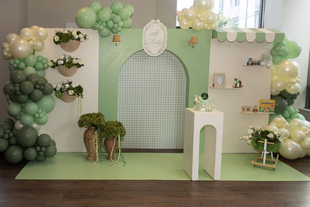 Full view of the Oh Baby balloon arch backdrop with floral wall baskets and styled shelving