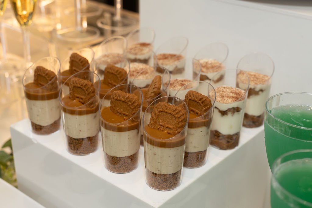 Layered dessert cups with cookie crumble topping on the dessert table