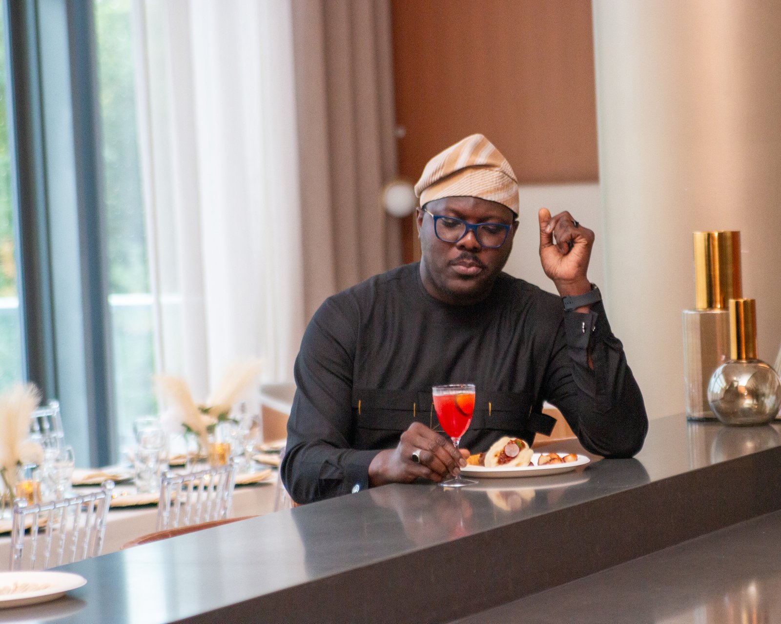 Guest at the bar enjoying a signature cocktail and plated appetizers
