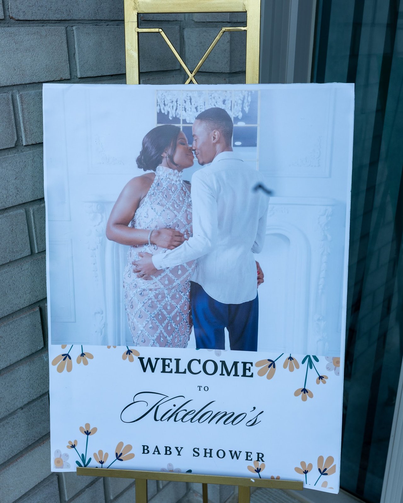 Welcome signage for Kikelomo's baby shower on a gold easel at the entrance