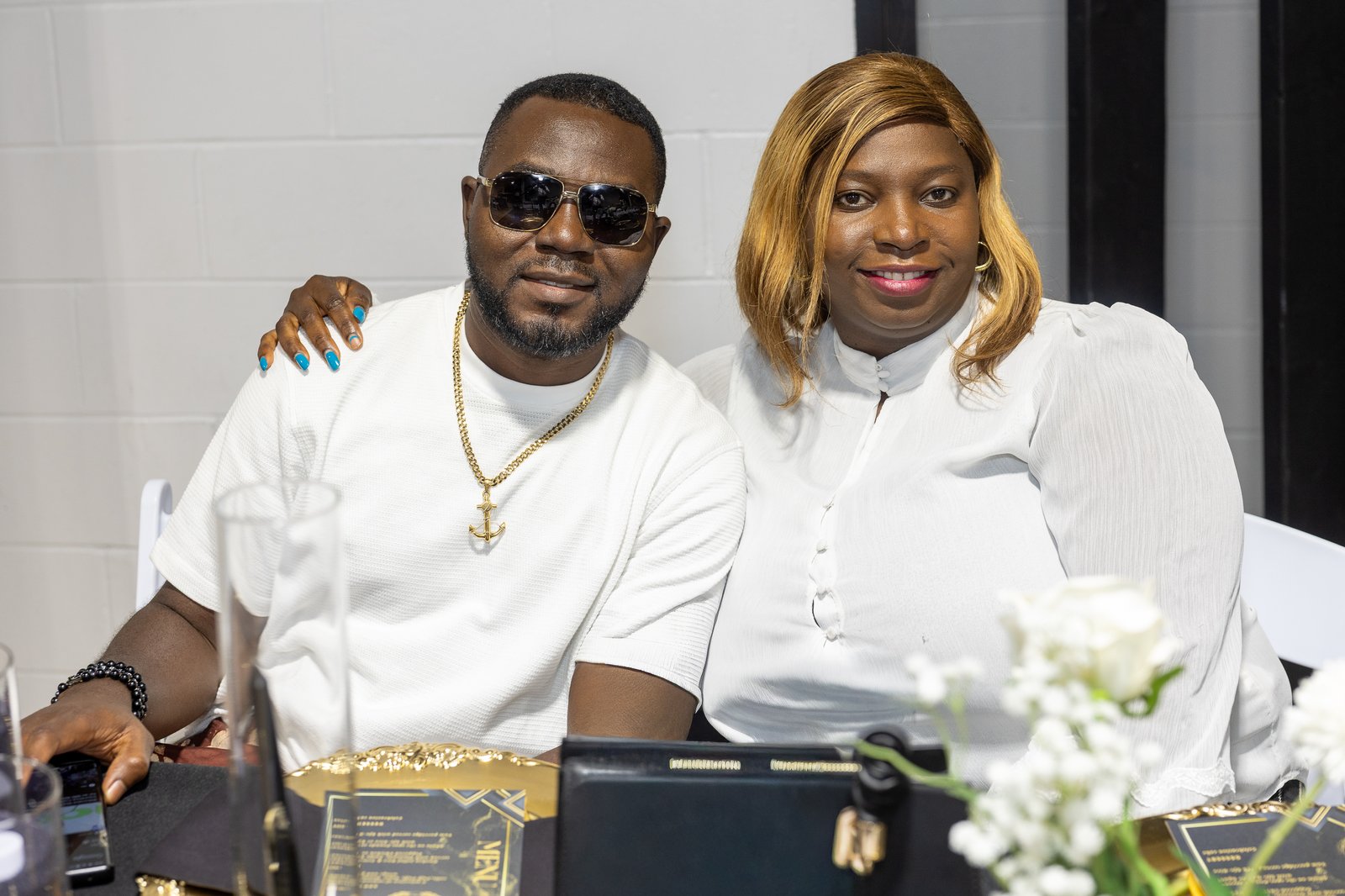 Couple portrait dressed in white with gold accents at the celebration