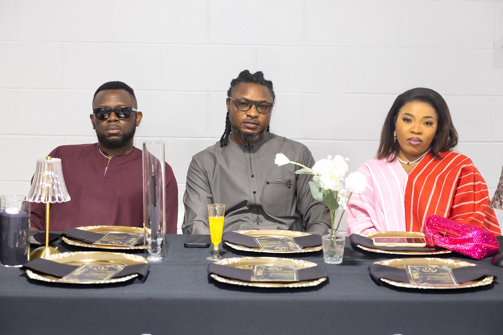 Three guests seated together at a black and gold table