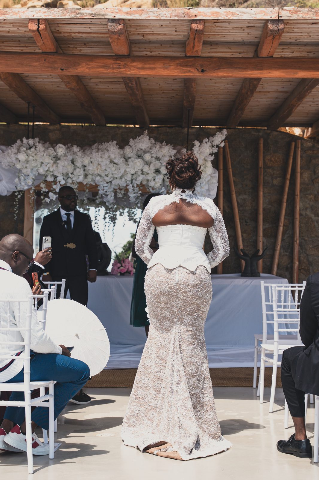 The ceremony arch dressed in white florals, guests seated