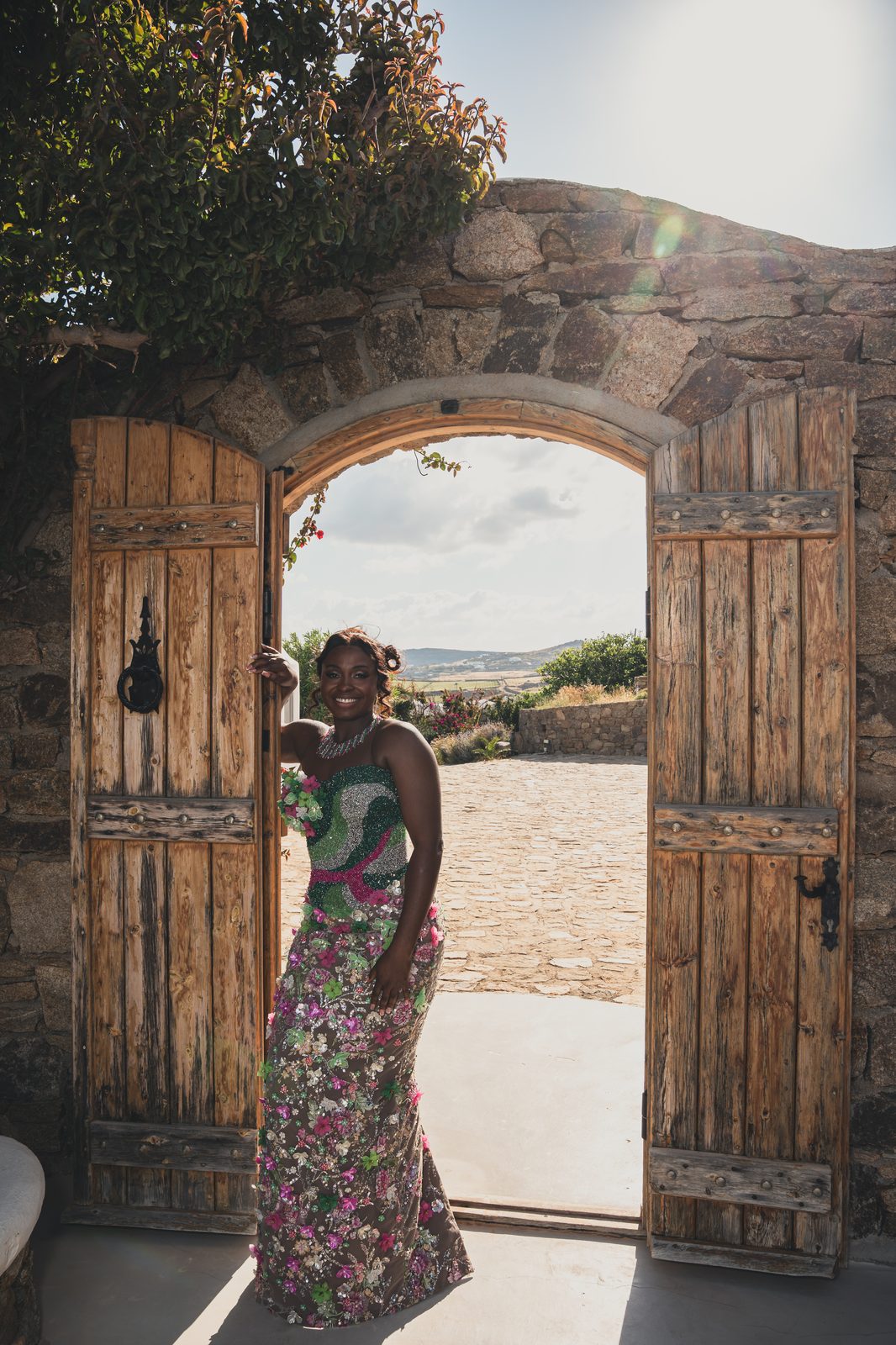 The bride framed in a rustic stone archway doorway overlooking the countryside