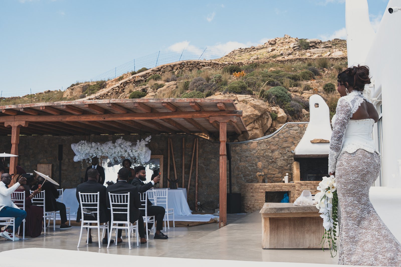 Ceremony seating set under a floral pergola overlooking the sea