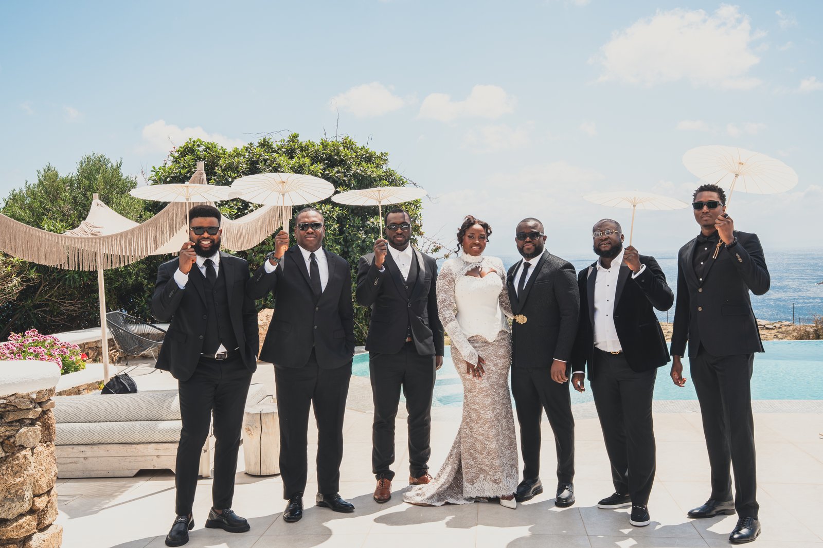 The wedding party posing together on the terrace overlooking the sea
