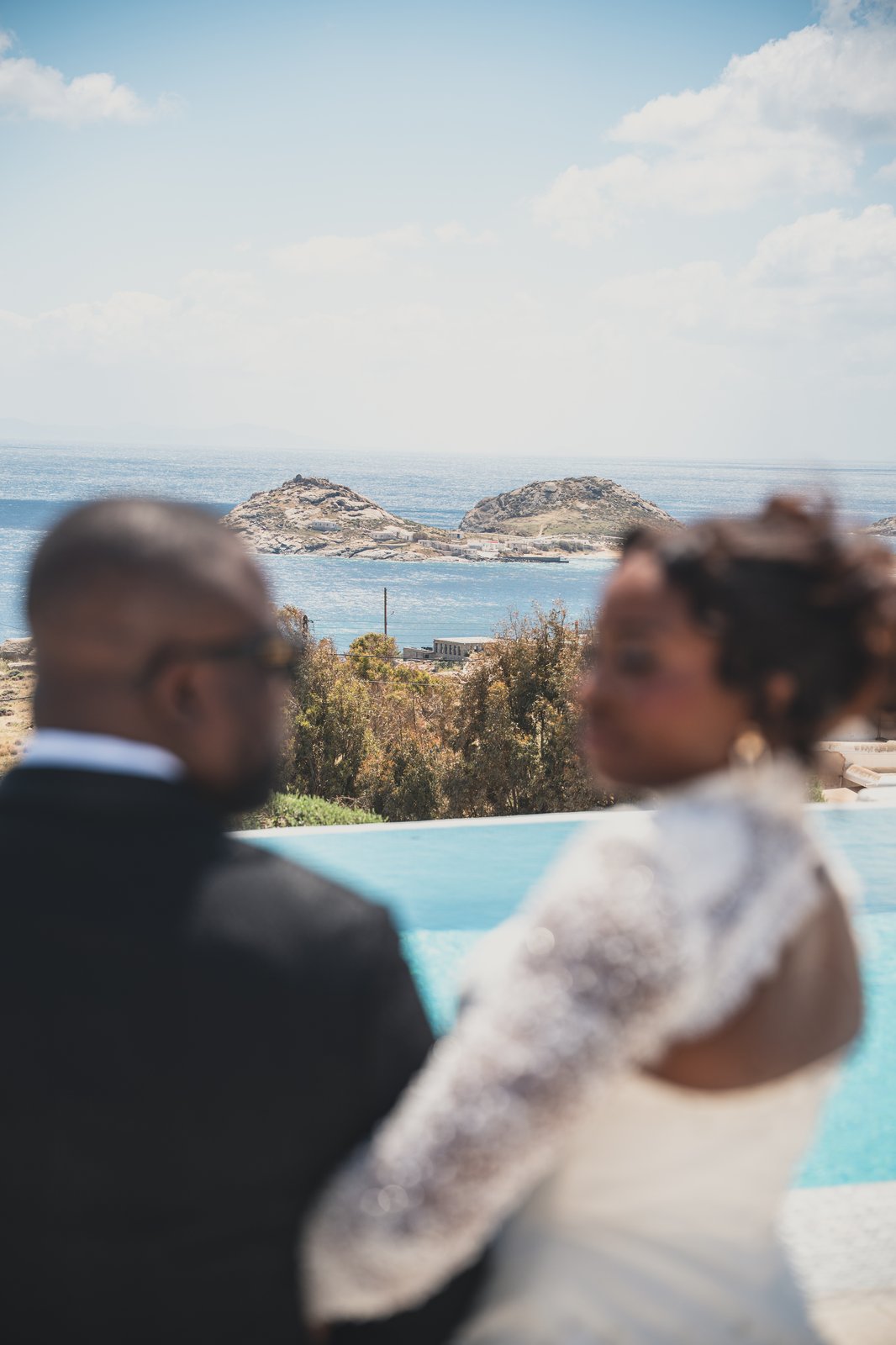 The couple walking arm in arm with the sea in the background
