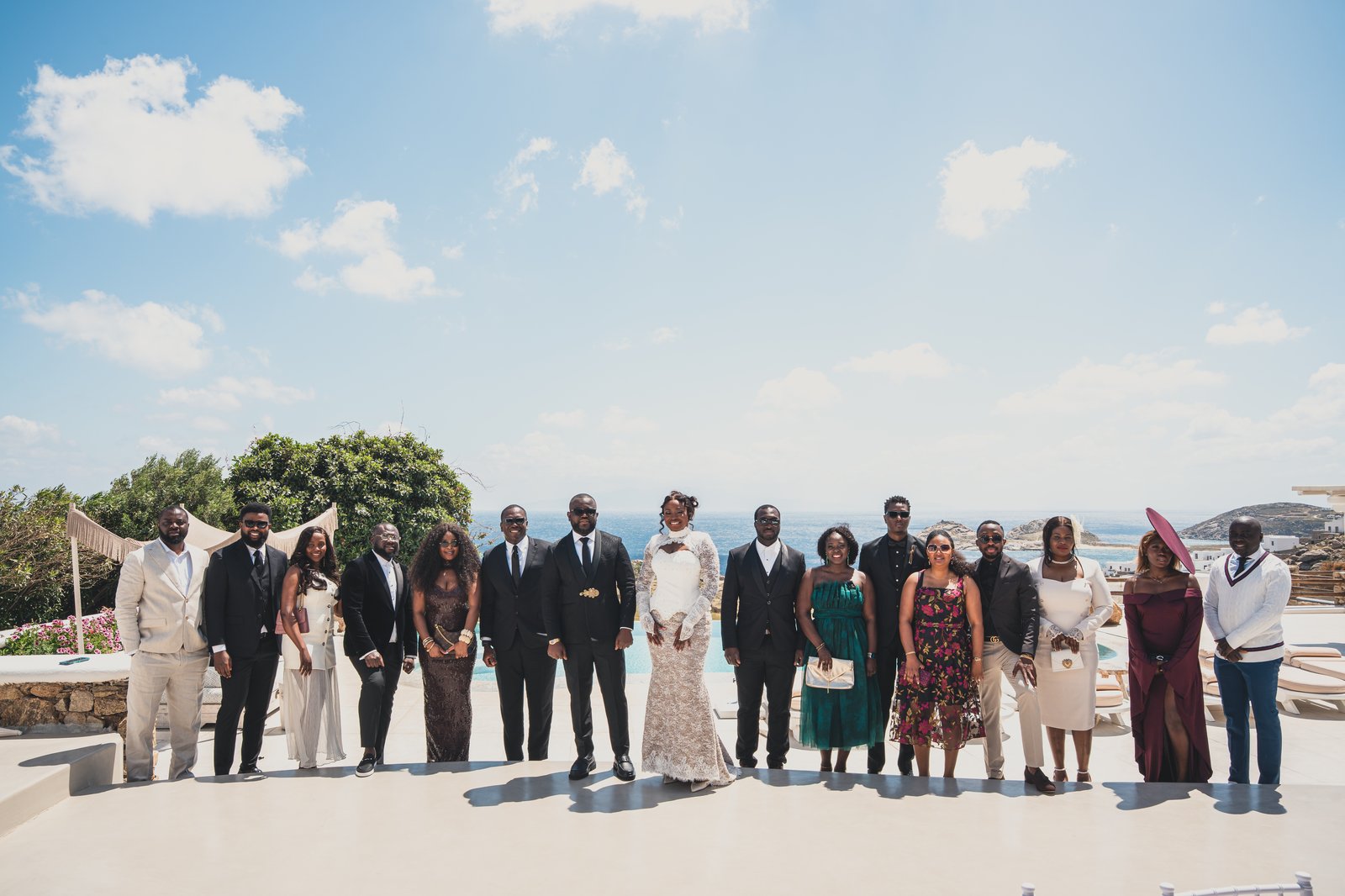The wedding party and guests posing for a group photo by the pool