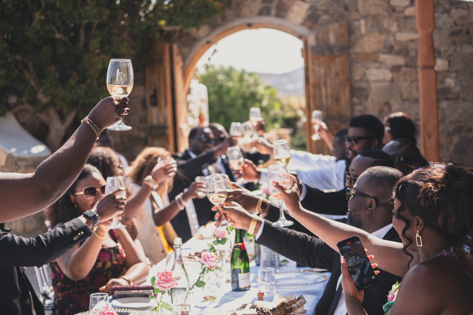 Guests raising their glasses in a champagne toast at the reception table