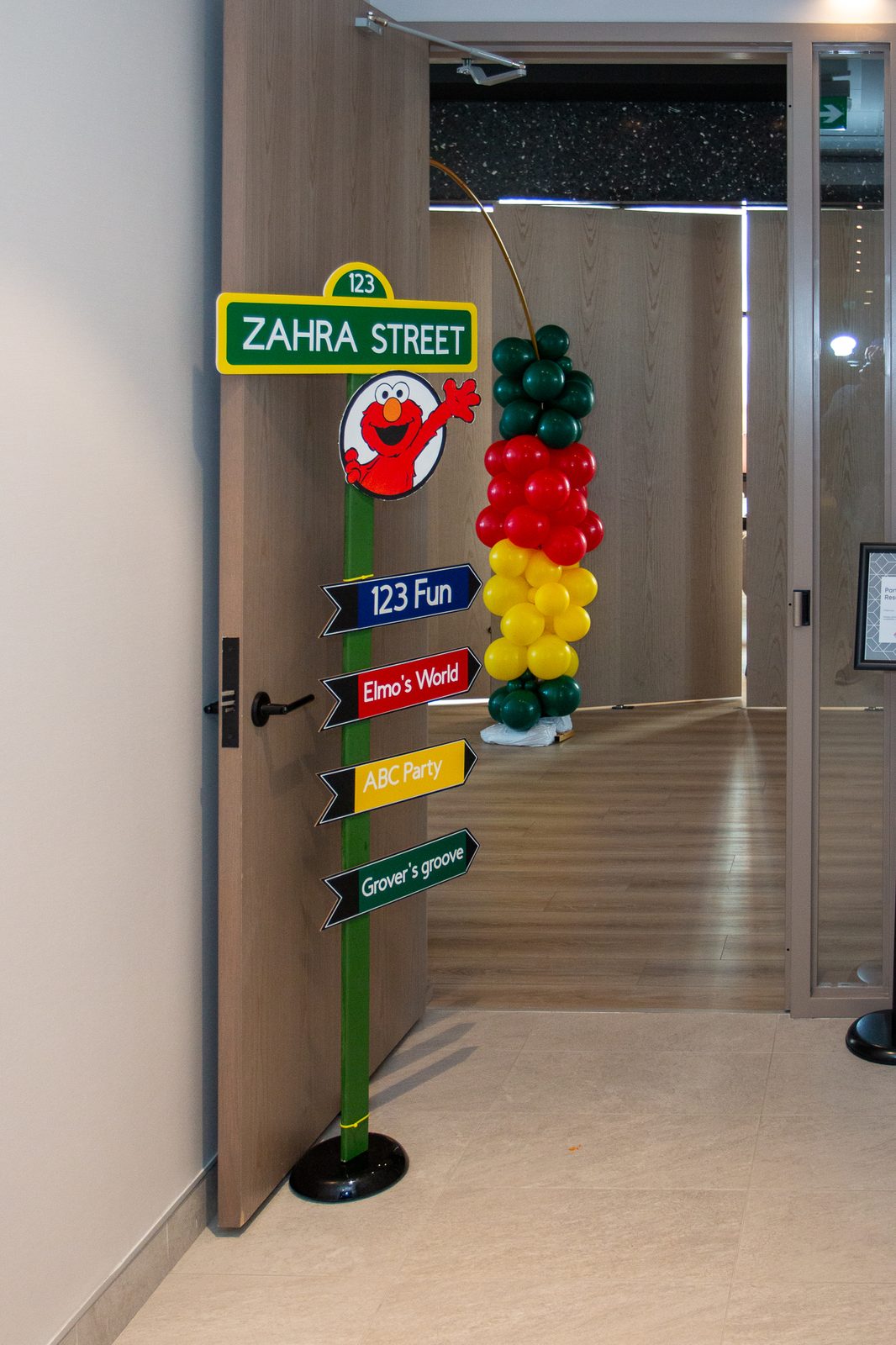 Zahra Street custom entrance signage with Elmo and balloon columns