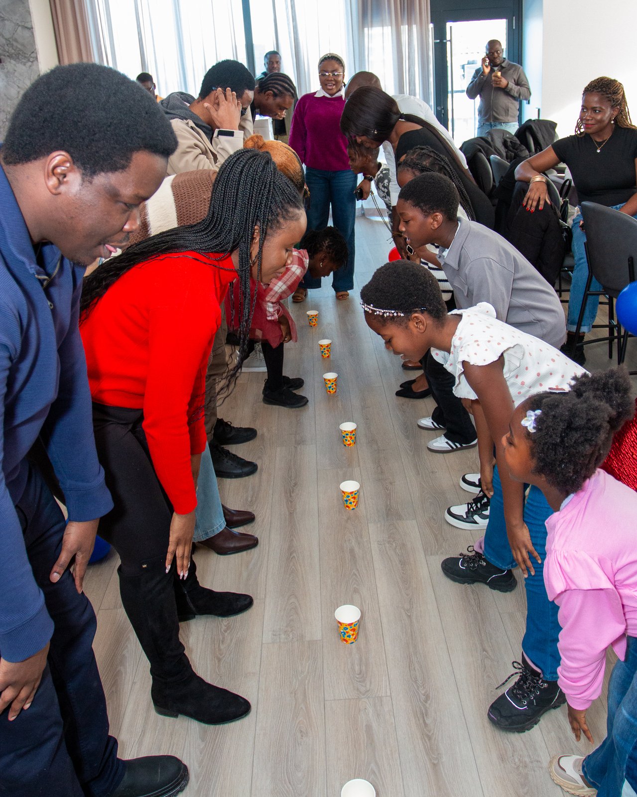 Guests lined up bent over a row of party cups, playing a group game