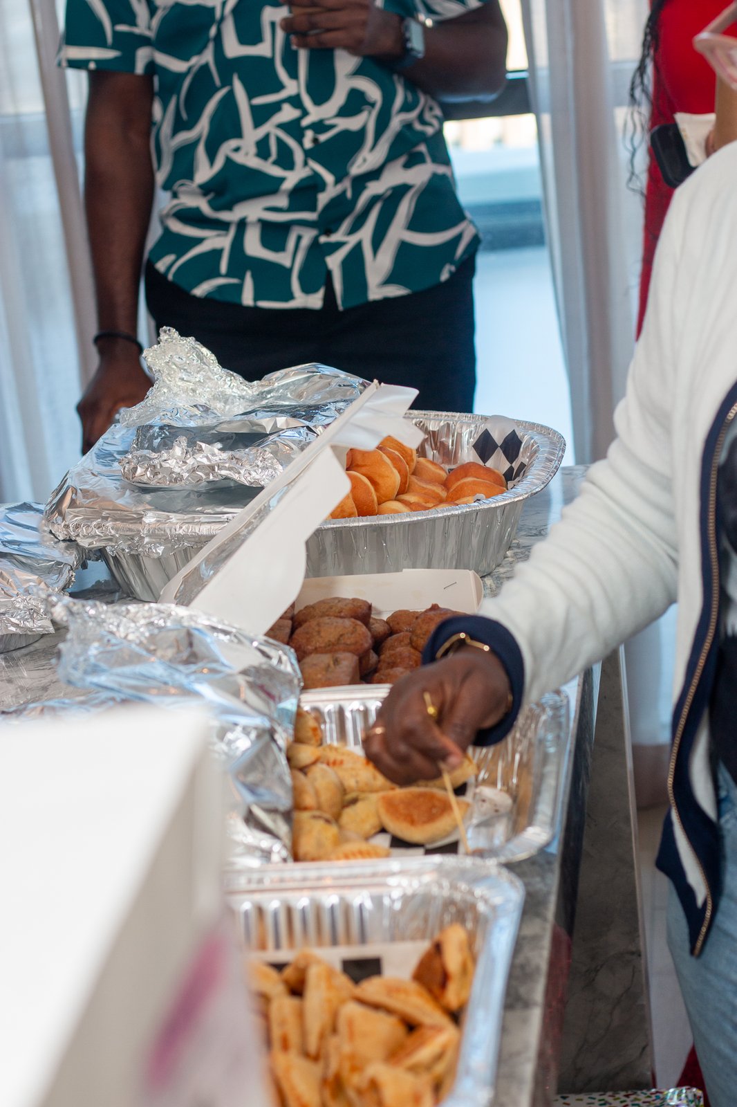 A guest serving pastries and snacks from the buffet table