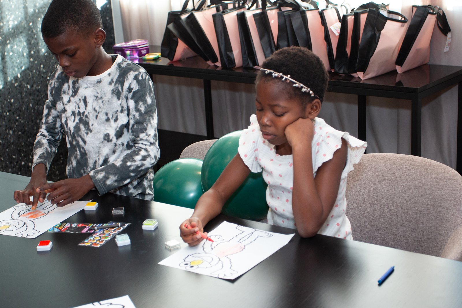 Two girls doing crafts and coloring at the activity table