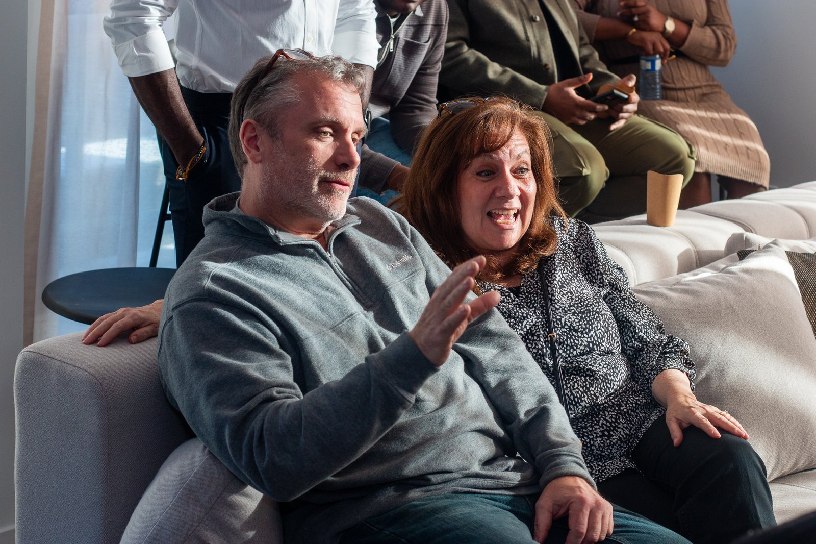 Guests relaxing together on the couch during the party